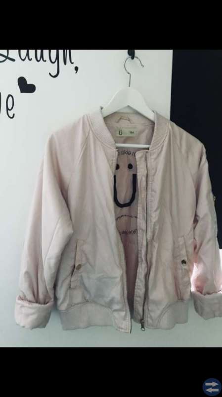En rosa bomber jacka med guld detaljer